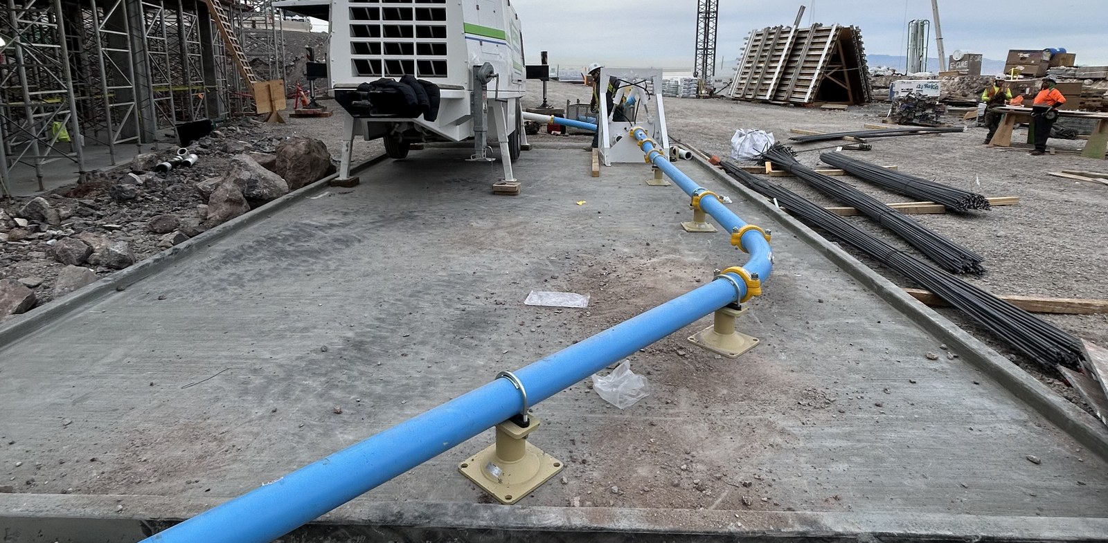 Floor bracket stands anchoring a 5-inch line down the deck to the pump trailer