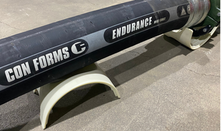 Con Forms Endurance line pipe resting in a non-marking hose support cradle on the jobsite